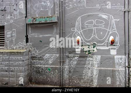 John Lennon mural with Volkswagen Beetle artwork on Mathew Street, Liverpool, England, celebrating Beatles heritage and music tourism Stock Photo