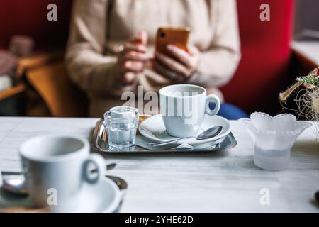 Coffee break. Woman using her smartphone in cafe Stock Photo