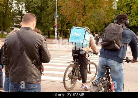 Wolt food delivery rider on a bicycle waiting at a pedestrian crossing in Tallinn - Estonia Stock Photo