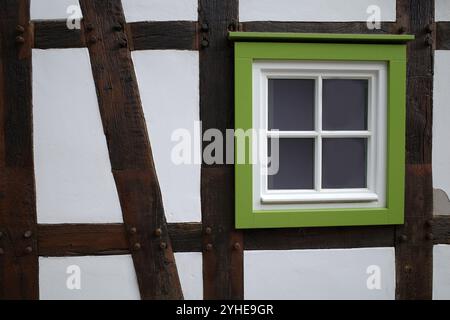 White wall of a half-timbered house with a green window frame Stock Photo