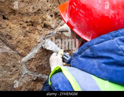 Forming decorative seams on a natural stone wall Stock Photo