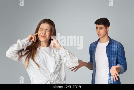 Young couple quarreling, lady covers ears with hands Stock Photo