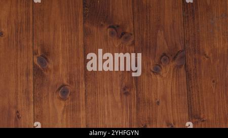 Close-up view of a dark wooden panel featuring unique knots and a rich, deep brown texture that enhances its natural and sophisticated appearance Stock Photo