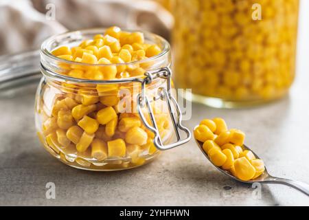 Canned sweet corn in jar on a kitchen table. Stock Photo