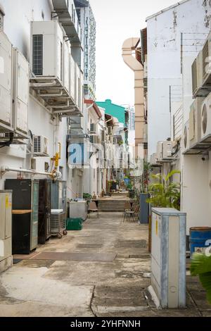 Alleyway between shophouses in Singapore with Air conditioner condenser units along the walls.The need for air conditioning is a carbon footprint challenge Stock Photo