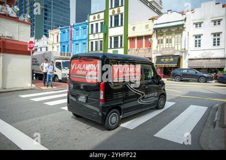 Lalamove delivery van waits at the junction of South Bridge road Singapore amongst the traditional shophouses. Stock Photo