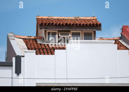 A extended roof of a shophouse in Singapore providing an opening with windows to help with ventilation and heat escape. Stock Photo