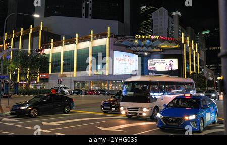 Nightime scene of Chinatown point shopping centre with traffic and road junction in the foreground on Upper Cross street Chinatown Singapore Asia Stock Photo