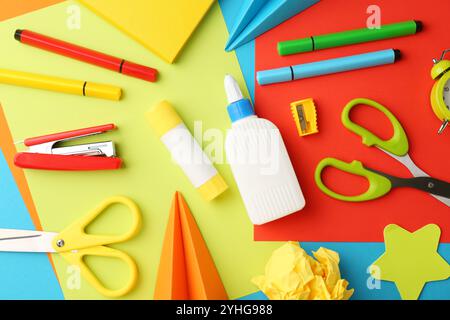 Flat lay composition with glue, scissors and other stationery on color background Stock Photo