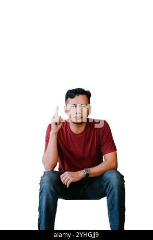 Southeast Asian man pointing upward with a focused expression, ideal for themes of direction, inspiration, or emphasis. Stock Photo
