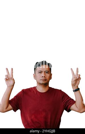 Southeast Asian man making a 'peace' sign with two fingers, symbolizing the number two. Ideal for themes of positivity, counting, or gestures." Stock Photo