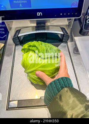 female hand putting the fresh cabbage on Self-Checkout Machine at Store. High quality photo Stock Photo