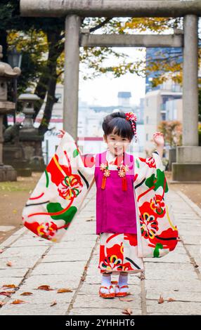 A happy girl in kimono with her hands raised Stock Photo