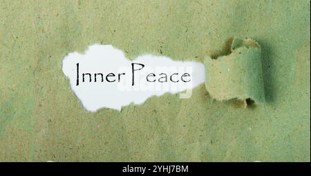 Inner peace message written on ripped torn paper piece with green background. Conceptual Inner Peace symbol. Copy space. Stock Photo