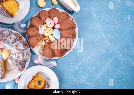 Traditional cake for Easter. Chocolate and vanilla Easter round cake with chocolate and sugar powder sprinkles, colorful Easter eggs, spring flowers, Stock Photo