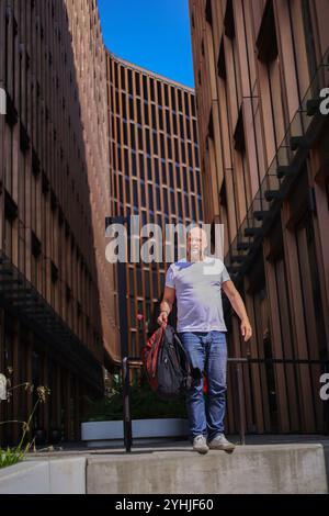 Old businessman middle-aged Caucasian employee senior business man worker dancing walking down stairs office in city happy good mood success jump Stock Photo