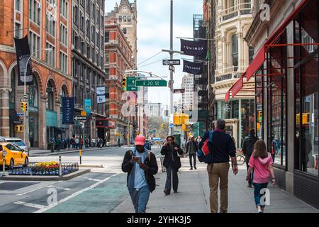 New York, USA - April 15, 2017: People walking along a busy street in SoHo with historic buildings and shops. Stock Photo