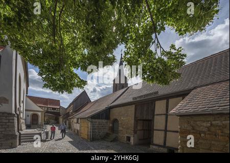 Inner courtyard with former so-called church arcades, barns in the historic fortified church, church of St John the Baptist at the back, Huettenheim, Stock Photo