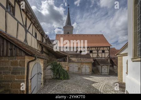 Former so-called Kirchgaden, barns in the historic fortified church, behind the tower of the church of St John the Baptist, Huettenheim, Lower Francon Stock Photo