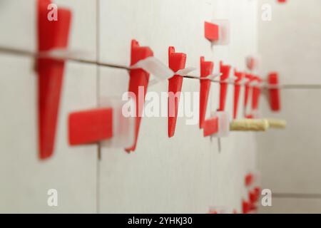 Flat wall plastic tile leveling system. Process of installation of tiles in the bathroom step by step. DIY home improvement. Stock Photo