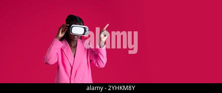A person in a pink blazer interacts with virtual reality in a bright studio Stock Photo