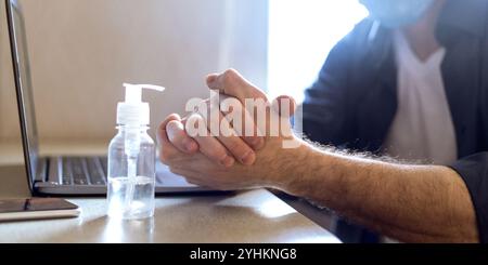Unrecognizable Man Using Sanitizer Disinfecting Hands Before Work, Panorama, Cropped Stock Photo