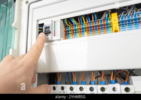 Hand Operating Electrical Circuit Breaker in Control Panel Stock Photo