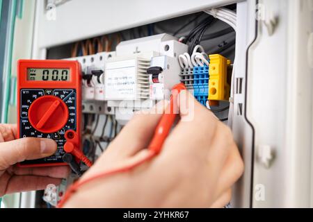 Electrical Technician Measuring Voltage with Multimeter Stock Photo