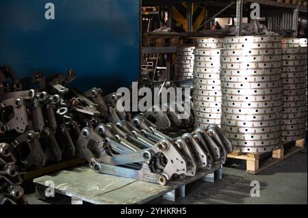 A factory storage area filled with stacks of industrial metal parts and components, ready for use in manufacturing or assembly. Stock Photo