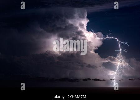 Mediterranean storm, opposite San Remo, Liguria, Italy. An extra-cloudy lightning bolt emerges from a cumulonimbus. Stock Photo