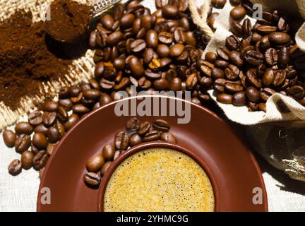 Espresso coffee on a background of coffee and ground beans on burlap. Arabica is the most common type of coffee. Stock Photo