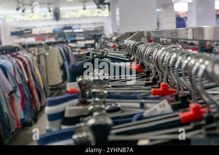 Close-up of empty hangers on a clothing rack in a retail store, ready for new merchandise. Stock Photo