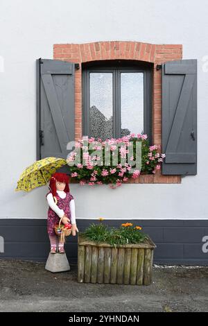 Mounaque of Campan, tall doll or puppet, holding an Umbrella or Parasol Posed in Front of Village House, Campan Hautes-Pyrénées Pyrenees France Stock Photo