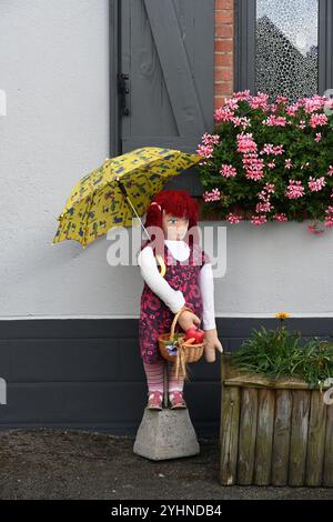 Mounaque of Campan, tall doll or puppet, holding an Umbrella or Parasol Posed in Front of Village House, Campan Hautes-Pyrénées Pyrenees France Stock Photo