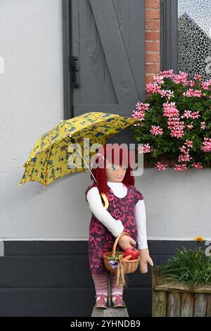 Mounaque of Campan, tall doll or puppet, holding an Umbrella or Parasol Posed in Front of Village House, Campan Hautes-Pyrénées Pyrenees France Stock Photo