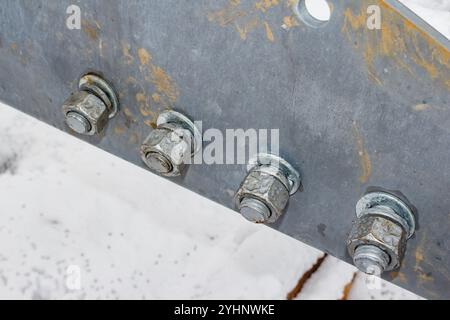 Nuts screwed onto large diameter bolts, light rust on fasteners Stock Photo