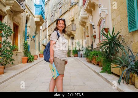 Woman traveler exploring touristic town Birgu on Malta island with a map Stock Photo