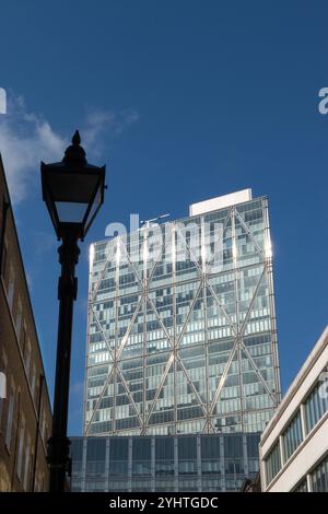 Broadgate Tower building from Folgate Street, contrasting architectural styles, modern glass and steel up against old fashioned traditional red brick buildings. Victorian street lamp still in situ. Spitalfields, London England Uk 2024 2020s HOMER SYKES. Stock Photo