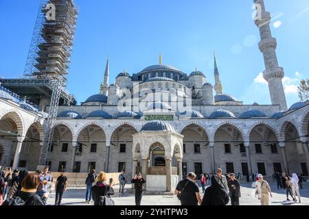 24/10/2024. The Blue Mosque, Istanbul, Turkey. View of the coutyard with one of the six minarets covered in scaffolding for repairs..  The Blue Mosque, officially the Sultan Ahmed Mosque (Turkish: Sultan Ahmet Camii), is an Ottoman-era historical imperial mosque located in Istanbul, Turkey. It was constructed between 1609 and 1617 during the rule of Ahmed I and remains a functioning mosque today. It also attracts a large number of tourists and is one of the most iconic and popular monuments of Ottoman architecture. The mosque has a classical Ottoman layout with a central dome surrounded by fou Stock Photo