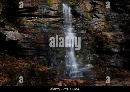 Rainbow in the mist of a waterfall in Ricketts Glen in Pennsylvania in Autumn Stock Photo