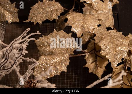 Full frame abstract texture background of an indoor holiday decoration featuring glitter covered leaves attached to a metal screen frame Stock Photo