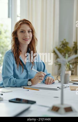 Woman Making Notes In Report At Meeting Stock Photo