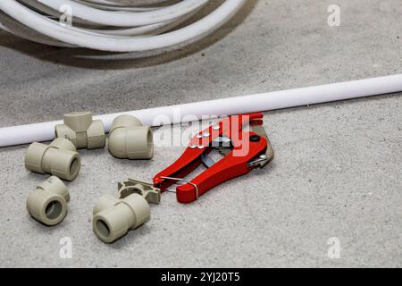 On the floor, there lies a pair of wrenches along with a pipe cutter, both essential tools used for various mechanical and plumbing tasks Stock Photo