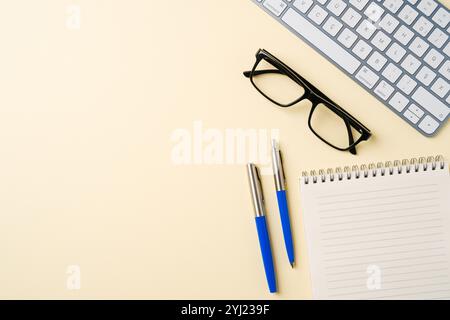 Office desk with computer keyboard, glasses, notebook and pen. Top view with copy space. Flat lay Stock Photo