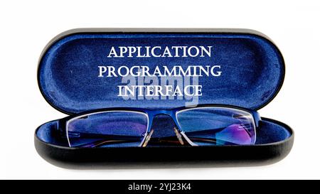 The concept of technology and development. Phrase, words, text APPLICATION PROGRAMMING INTERFACE written on the open case of the glasses case. Stock Photo