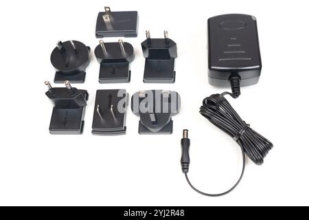 Power adapter showcased with various interchangeable plug types, arranged on a clean white background. Stock Photo