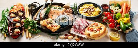 Assortment various Mediterranean food - fish, shrimp, seafood, ravioli, vegetables on a white background. Top view. Panorama. Stock Photo