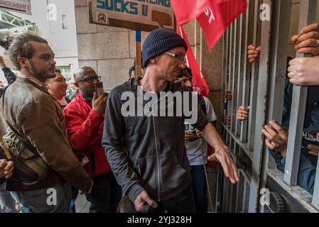 London, UK. 27th September 2017.  A security man tells Independent Workers Union of Great Britain President Henry Chango Lopez that the protesters must leave the lobby of Birkbeck College where they are holding a noisy protest. The workers include security staff who have not received the increases in salary promised to maintain differentials since 2011. The  noisy protest at the university with other precarious workers came after marching from an early morning 'End Precarious Labour!' rally at Transport for London on the day that Uber's appeal against the ruling that their drivers are workers Stock Photo