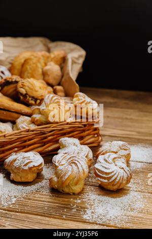 Close up of fresh cream filled pastries dusted with powdered sugar on a rustic wooden table Stock Photo