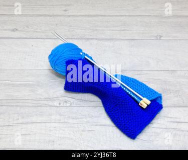 Dark and lighr blue knitting and a ball of light blue wool with Knitting needles Stock Photo